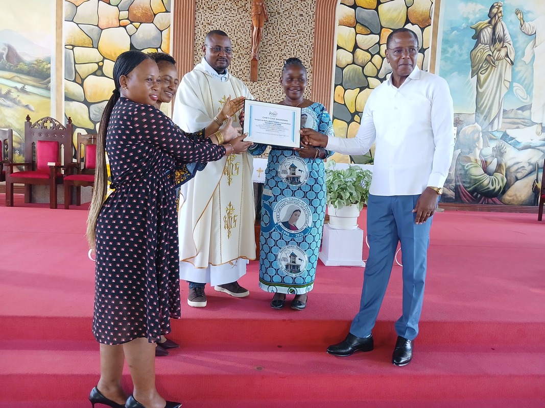 Kamati Tendaji Parokia ikipokea cheti kutoka Redio Maria